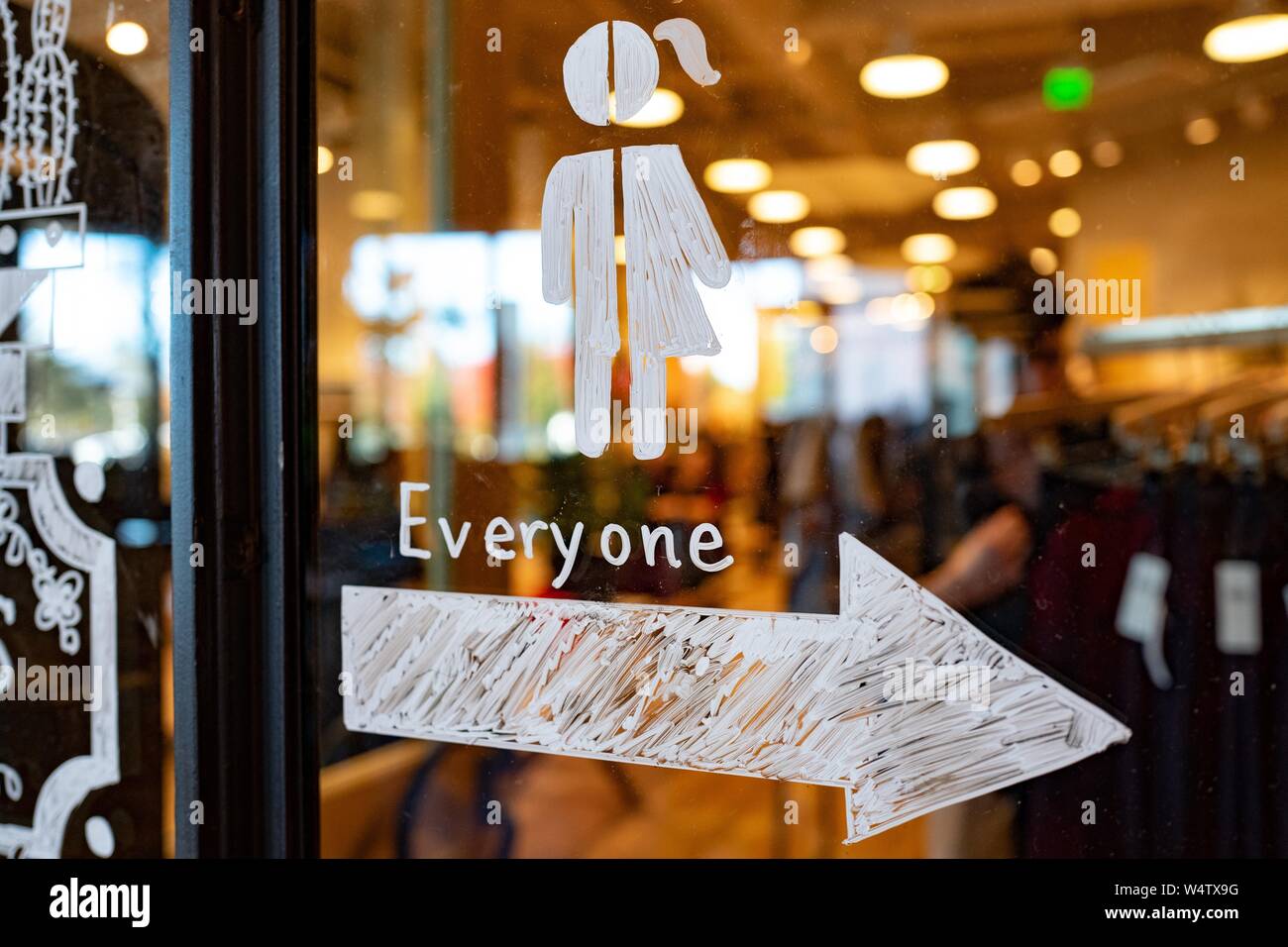 Close-up of hand drawn sign on a window depicting a stick figure which is half female and half male, with an arrow pointing towards an all gender restroom and text reading Everyone, at the Stanford Shopping Center in the Silicon Valley town of Palo Alto, California, November 24, 2018. () Stock Photo