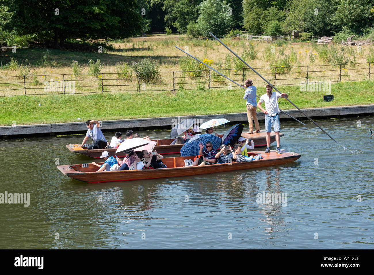 Cambridge UK,  25th July 2019. People enjoy punting on the River Cam on what is likely to be the hottest day on record in the UK.  With temperatures in the high 30’s centigrade tourists avoid the glaring sunshine under parasols and umbrellas. The temperature is set to rise to round 39 degrees as the heatwave in the south east of the UK continues. Credit Julian Eales/Alamy Live News Stock Photo