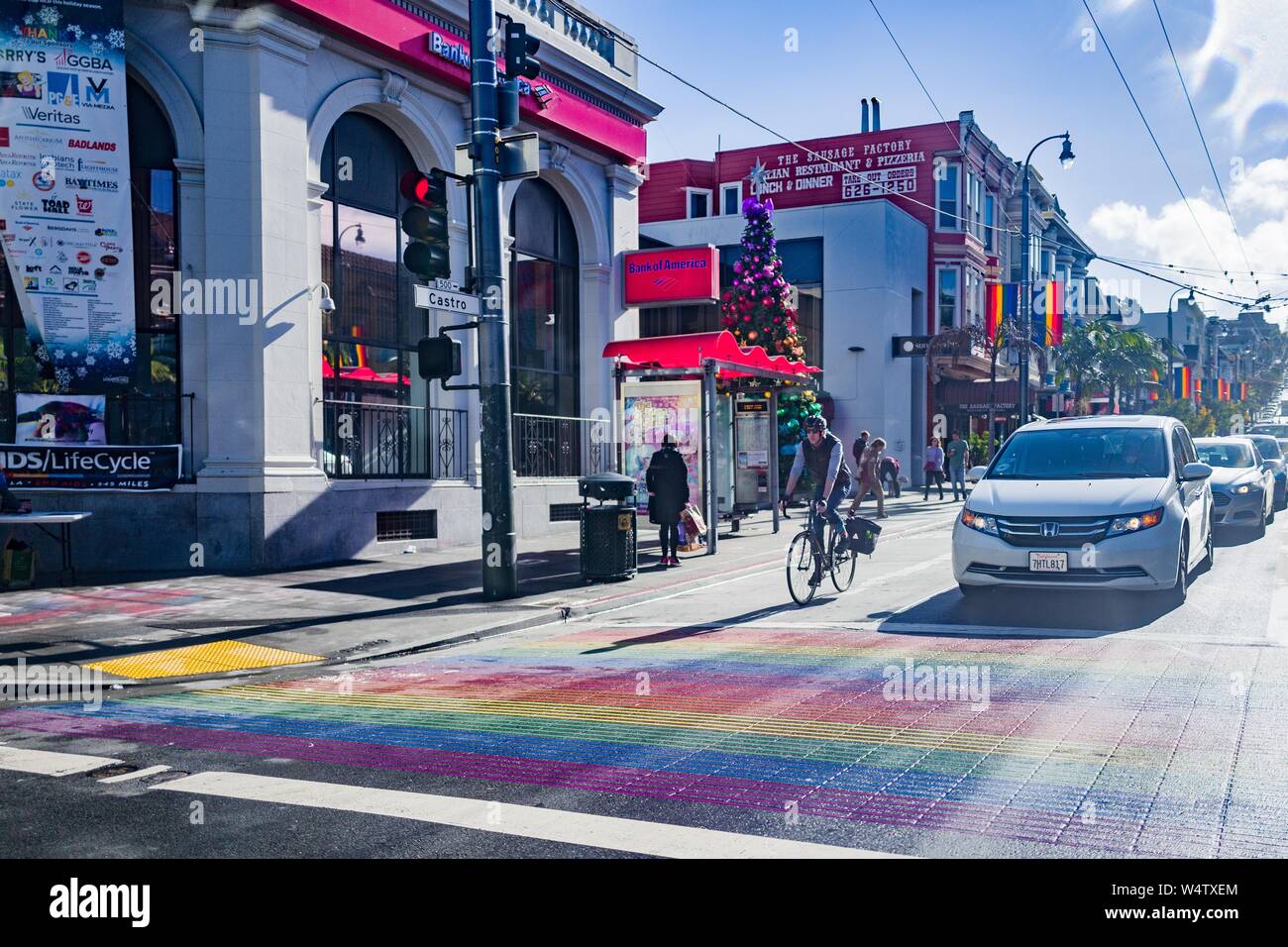 Cyclists and cars are visible approaching the Rainbow Crosswalk, part of the Rainbow Honor Walk commemorating LGBT leaders, on Castro Street in the Castro District of San Francisco, California, known as one of the major centers of LGBT culture in the United States, December, 2018. () Stock Photo