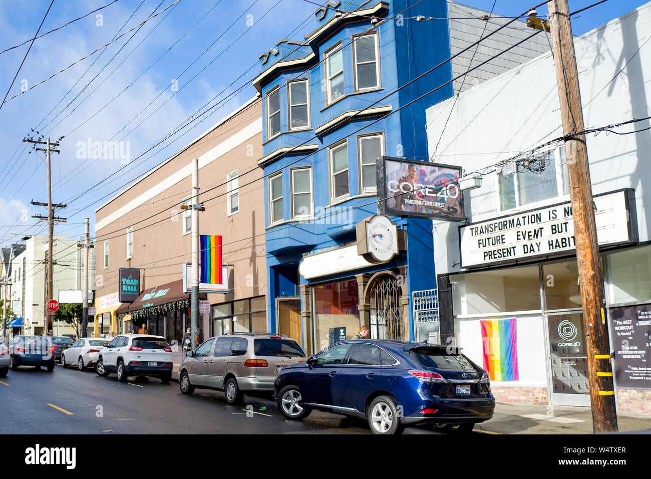 Numerous LGBT rainbow pride flags are visible on a sunny day on 18th street in the Castro District of San Francisco, California, known as one of the major centers of LGBT culture in the United States, December, 2018. () Stock Photo