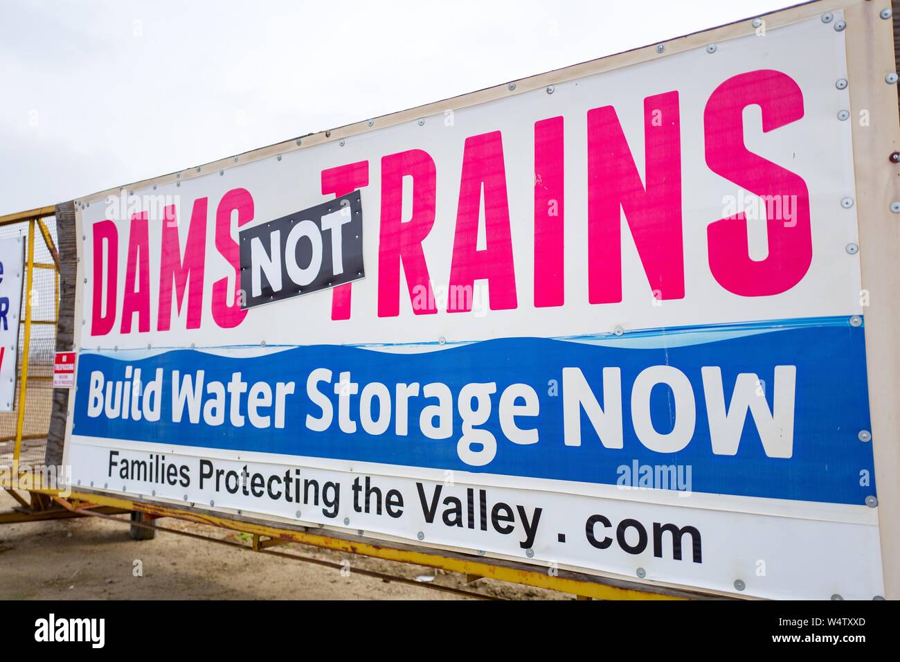 Sign in the San Joaquin Valley of California protesting water politics and the construction of high speed rail lines, with text reading Dams Not Trains, Build Water Storage NOW, along the Interstate 5 freeway, created by political group Families Protecting the Valley, December 9, 2018. () Stock Photo