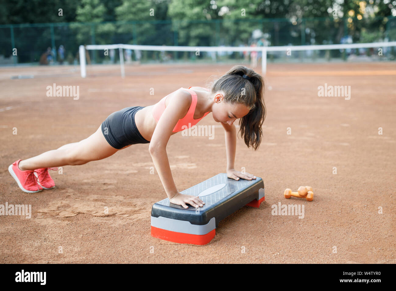 A cute, pretty teenage girl performs various outdoor exercises. Lifestyle Stock Photo