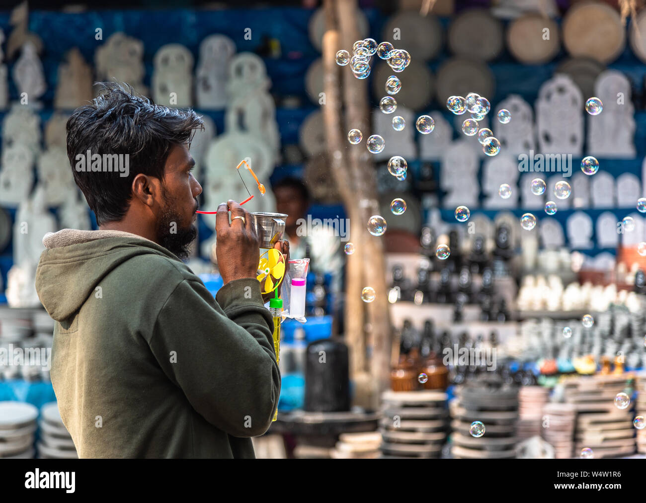 An unidentified Rural Indian salesman Blowing and selling Soap Bubbles with Bubble blower. Stock Photo