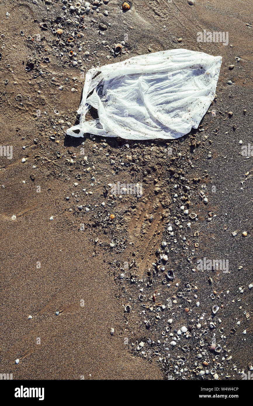 plastic bag polluting the beach, seashore and water pollution with