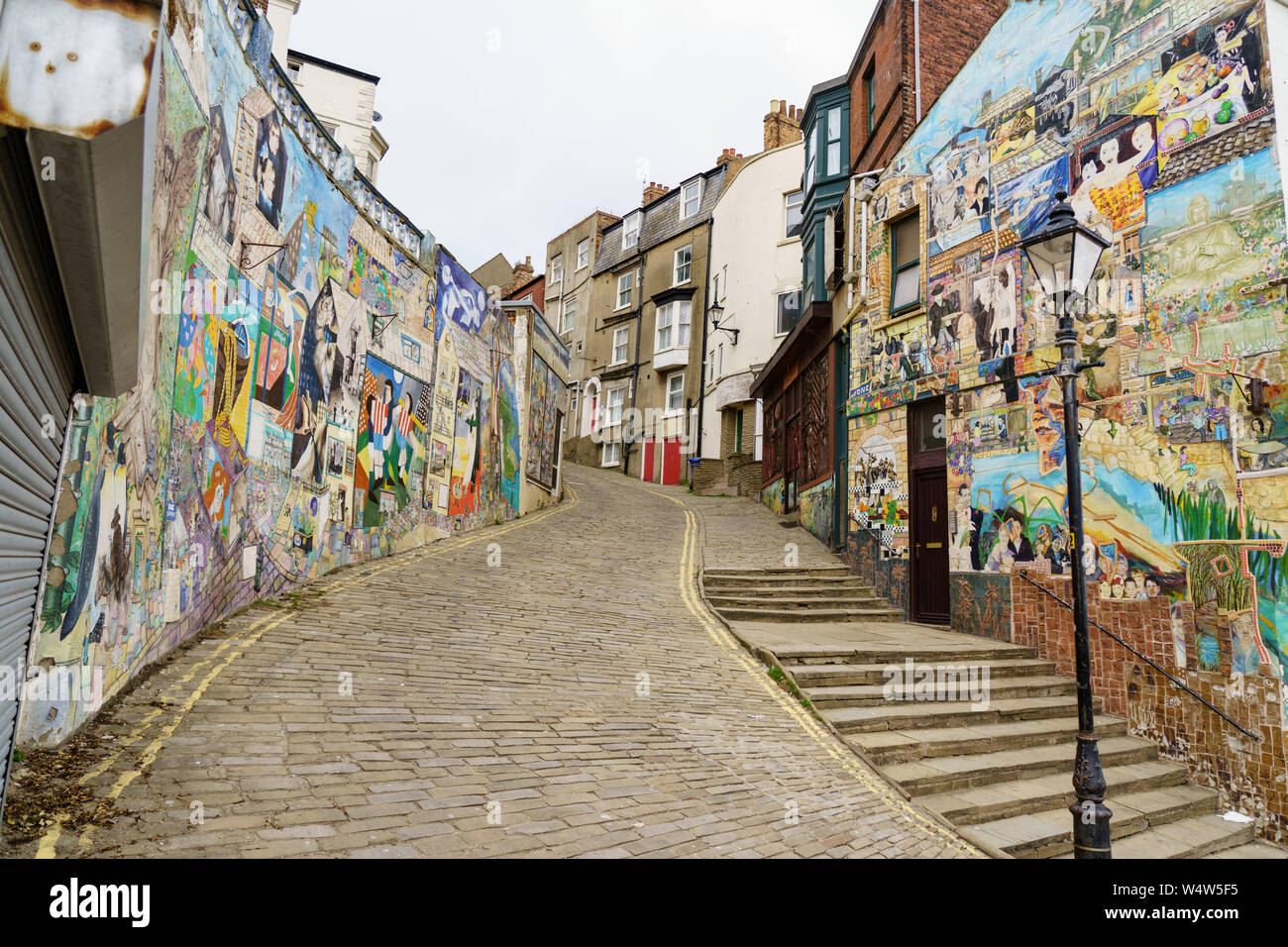 Steep Cobbled Street with Graffiti painted on the walls of the houses