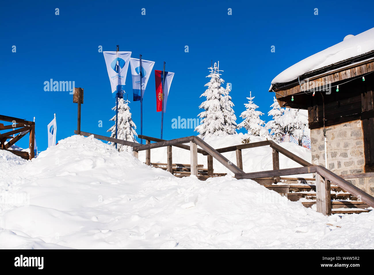 Kopaonik, Serbia - January 19, 2016: Serbian and ski resort flags on snowy mountain with trees background Stock Photo
