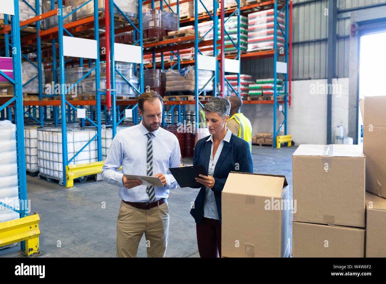 Staffs working together in warehouse Stock Photo - Alamy