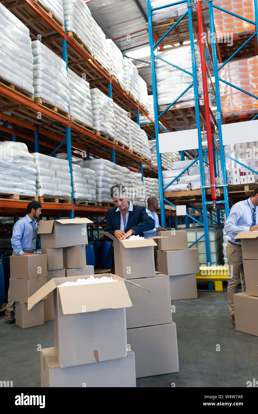 Diverse staff unpacking cardboard boxes in warehouse Stock Photo - Alamy