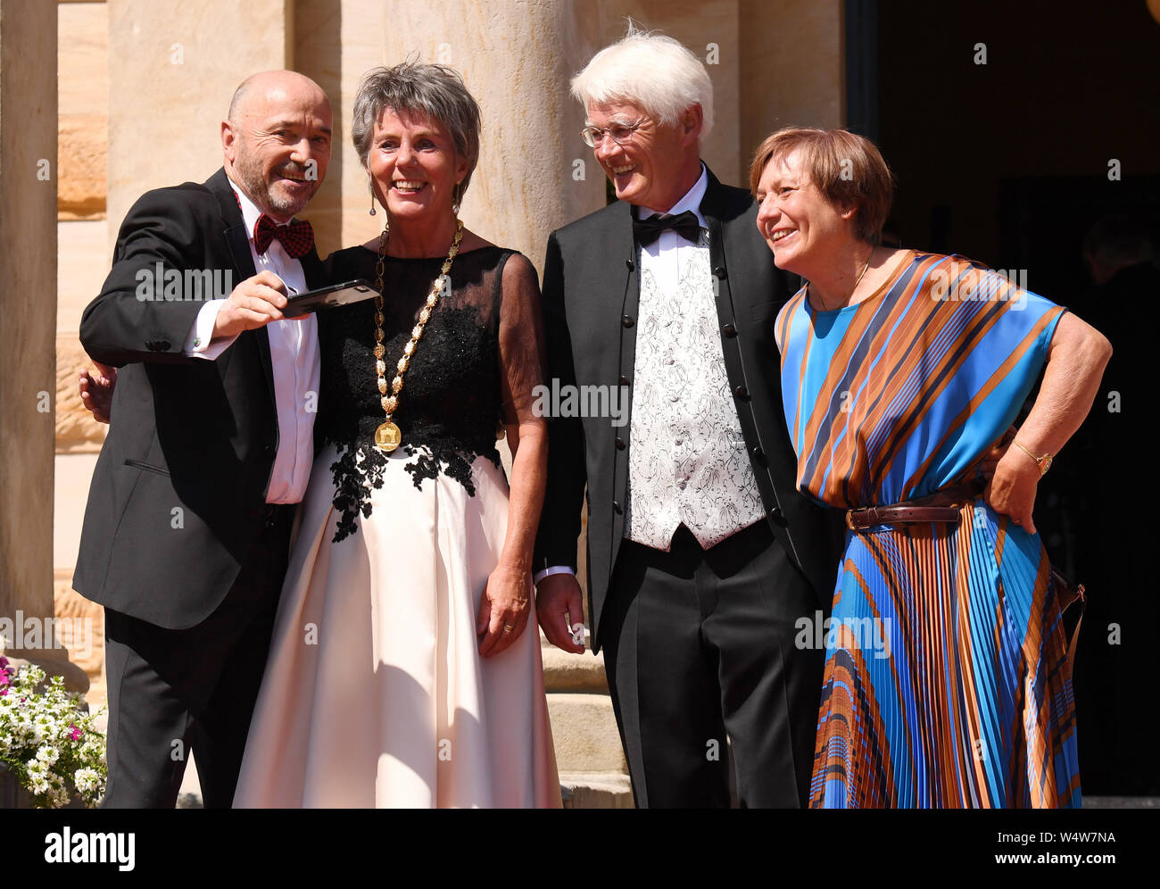 Bayreuth, Germany. 25th July, 2019. The former ski racers Rosi Mittermaier-Neureuther (r) and Christian Neureuther (l) arrive at the beginning of the Bayreuth Festival 2019 and are welcomed by the Mayor of Bayreuth Brigitte Merk-Erbe and her husband Thomas. The Richard Wagner Festival begins in Bayreuth on Thursday. Numerous celebrities are expected on the red carpet. (To dpa 'Bayreuth Festival start in heat with new 'Tannhäuser'') Credit: Tobias Hase/dpa/Alamy Live News Stock Photo