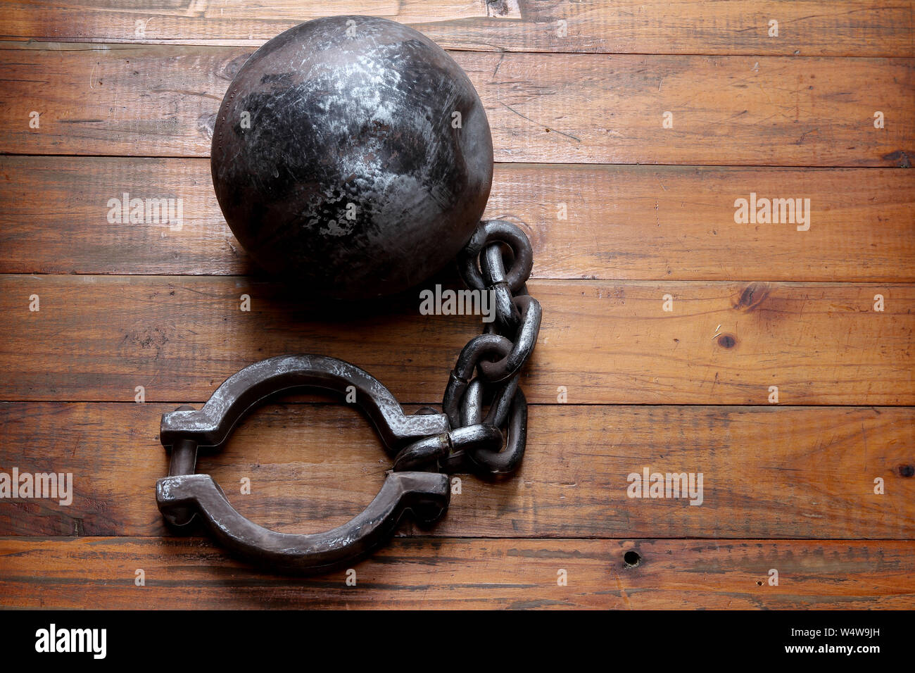 Prison Shackle on Wooden Background Stock Photo