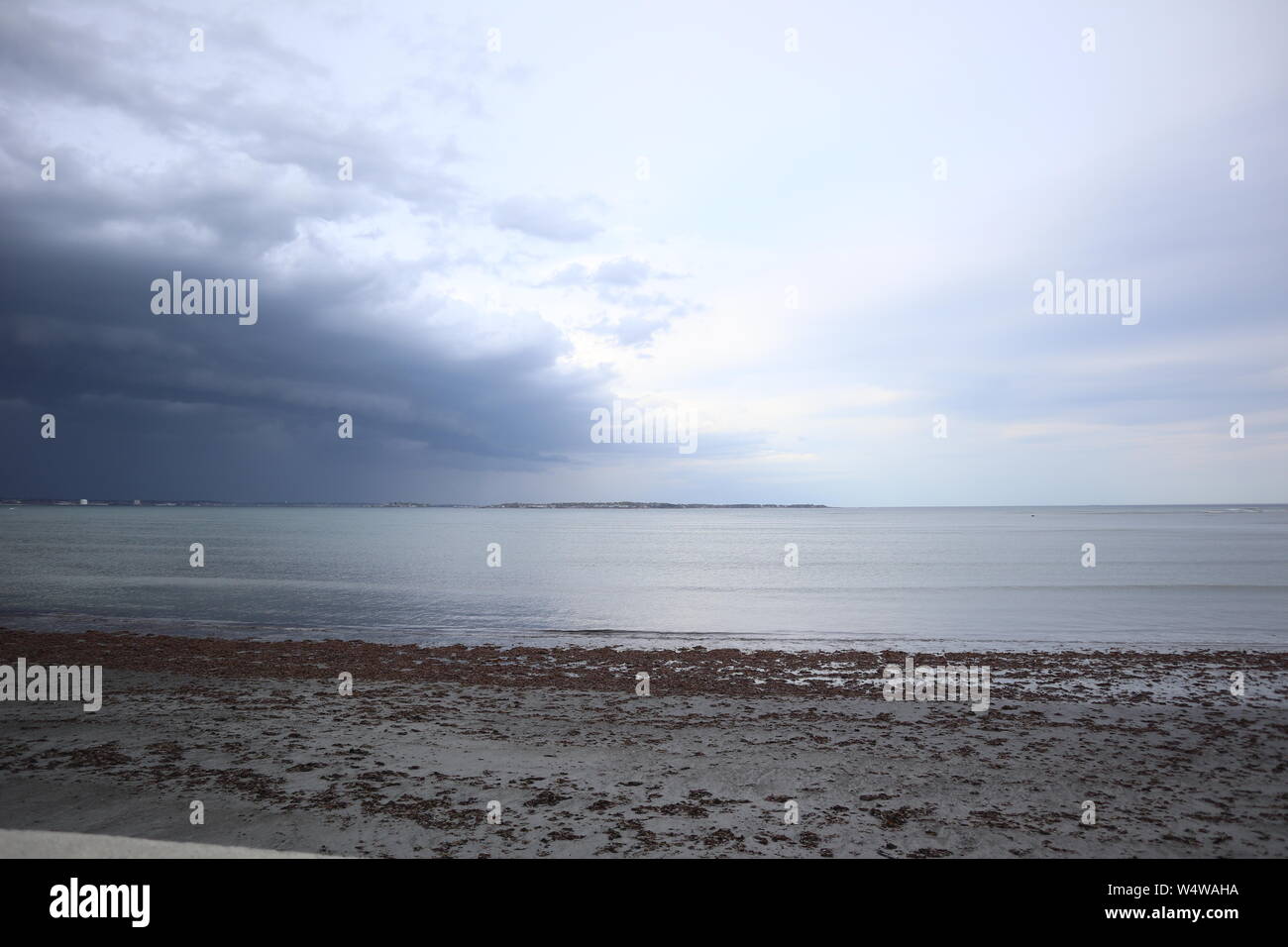Dark Clouds Rolling Over Beach Stock Photo