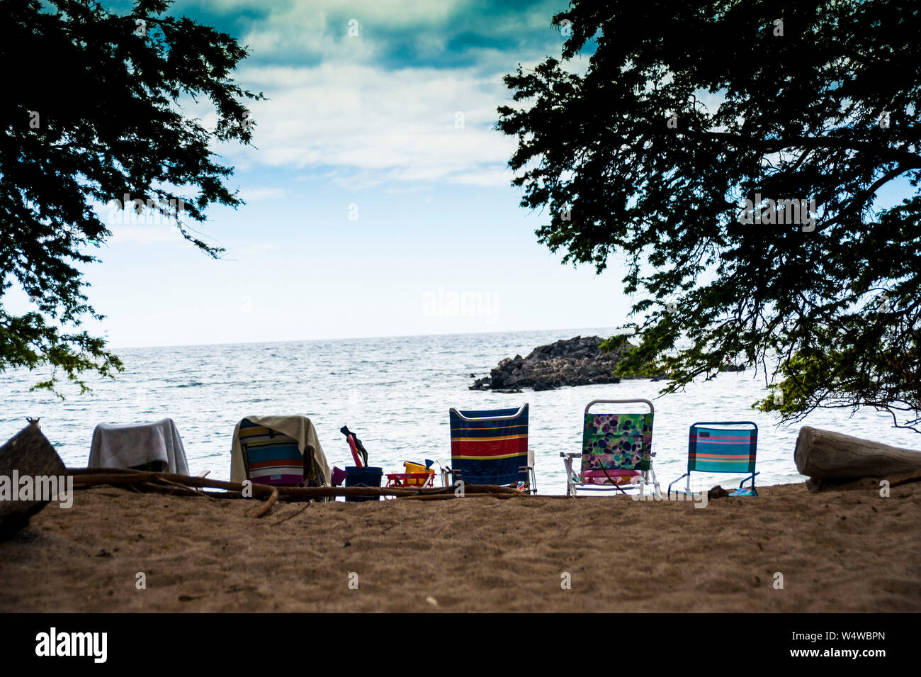 Row of beach chairs on a remote beach on the Big Island of Hawaii Stock Photo