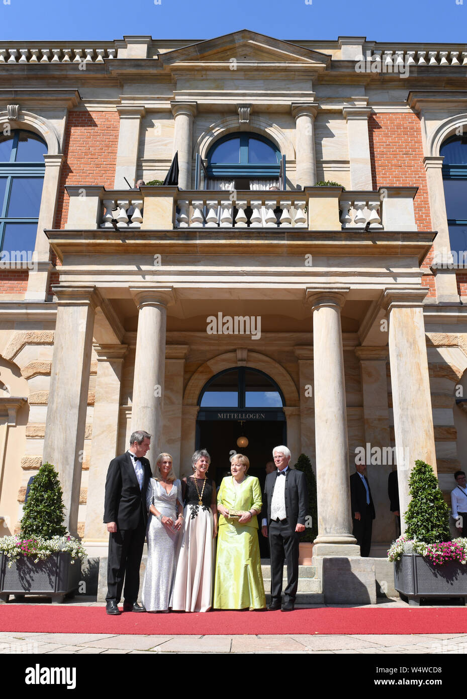 Bayreuth, Germany. 25th July, 2019. Markus Söder (CSU, l-r), Bavarian Prime Minister, his wife Karin Baumüller-Söder, Brigitte Merk-Erbe, Mayor of Bayreuth, Federal Chancellor Angela Merkel (CDU) and Thomas Erbe will be together at the beginning of the Bayreuth Festival 2019. The Richard Wagner Festival begins in Bayreuth on Thursday. Numerous celebrities walked the red carpet. (To dpa 'Bayreuth Festival start in heat with new 'Tannhäuser'') Credit: Tobias Hase/dpa/Alamy Live News Stock Photo