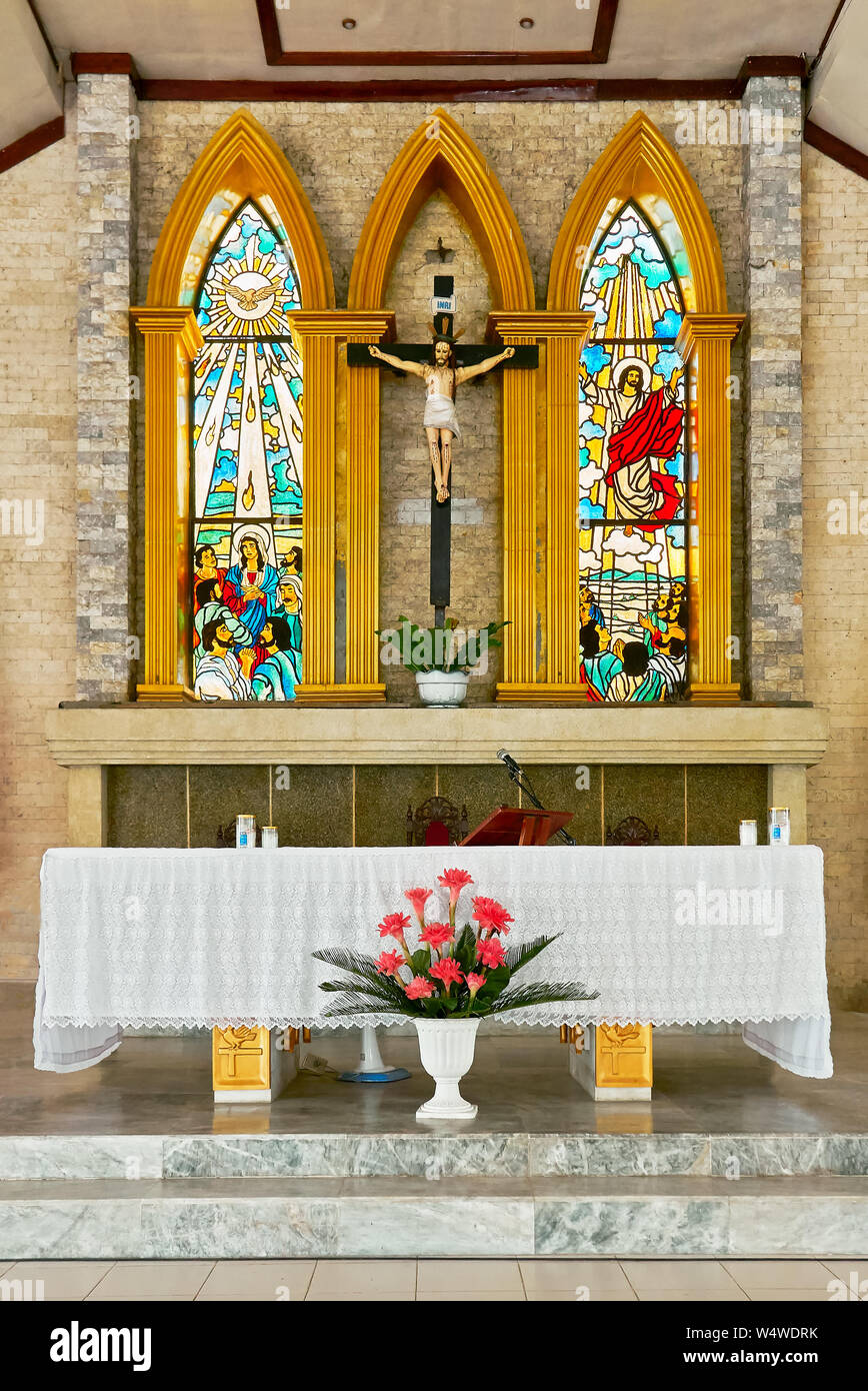 Altar and colorful painted windows inside the church of San Antonio de Padua surrounded with garden in Cuartero town, Capiz Province, Philippines Stock Photo