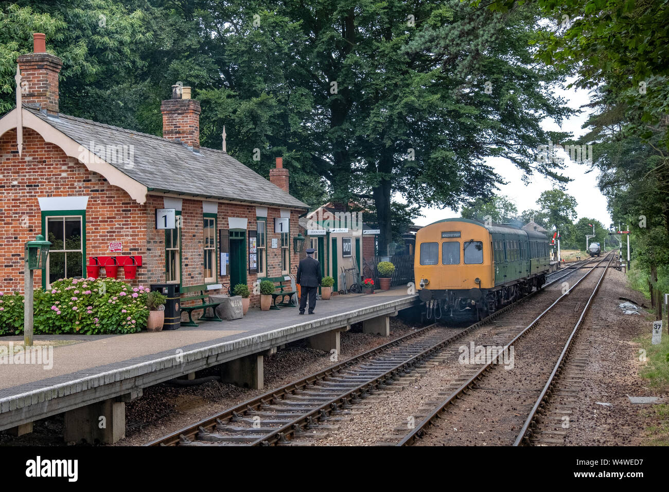 A diesel train beside the platform at Holt railway station in Norfolk ...