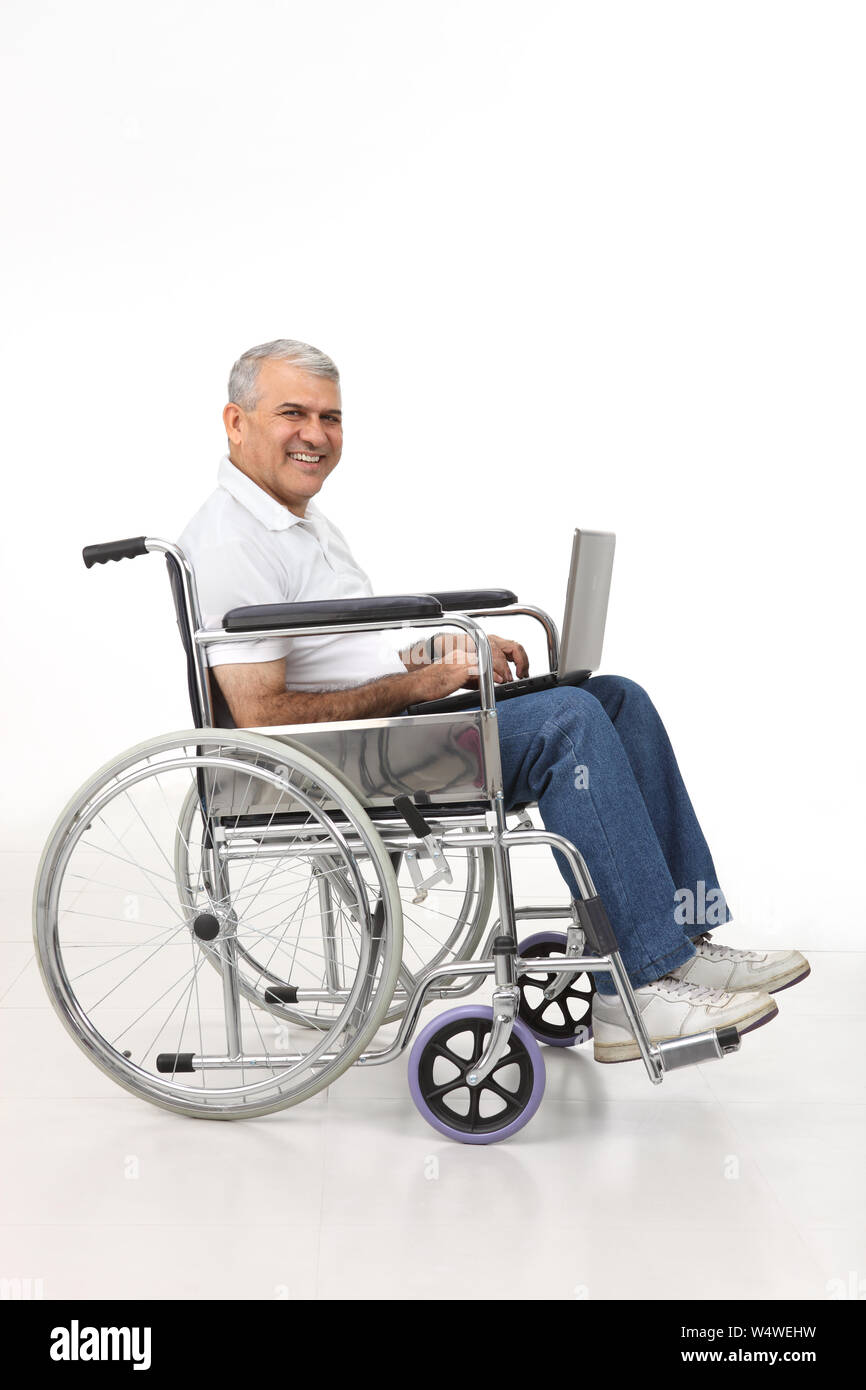 Disabled man working on a laptop Stock Photo