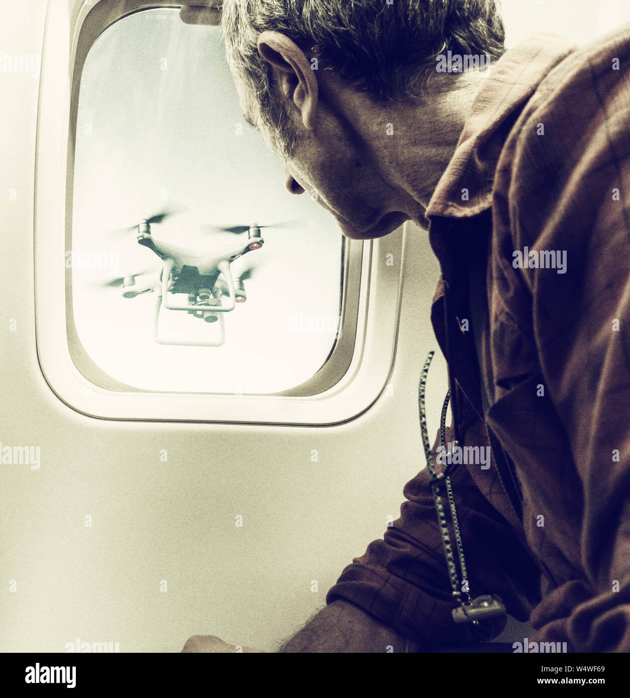 Man looking at drone through airplane window. Drone, airport concept Stock Photo