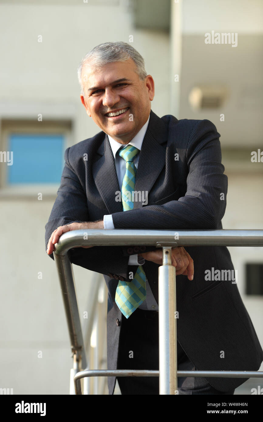 Chest Leaning Against Railing Businessman leaning against railing Stock Photo - Alamy