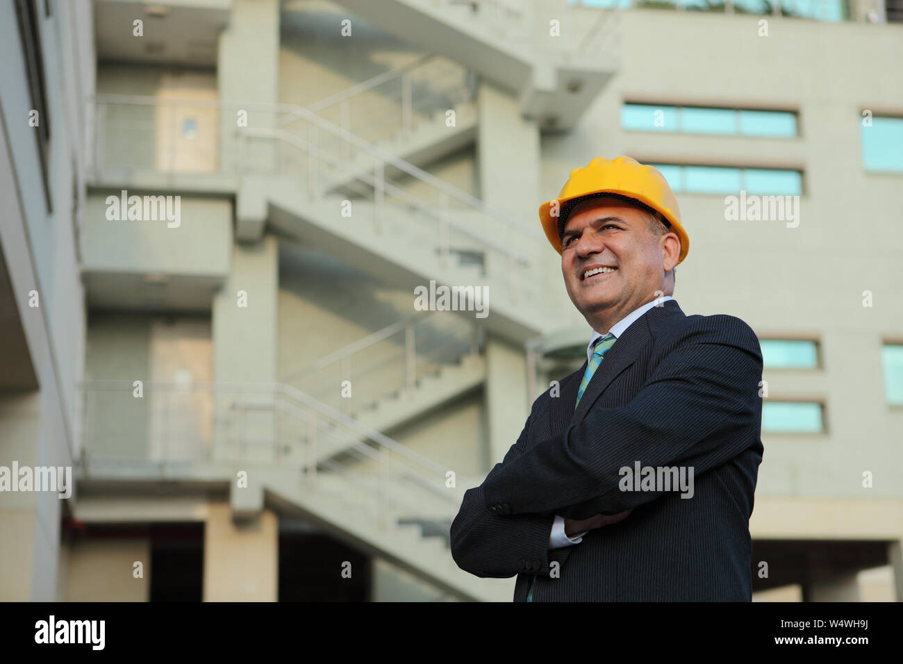 Businessman smiling with his arms crossed Stock Photo - Alamy