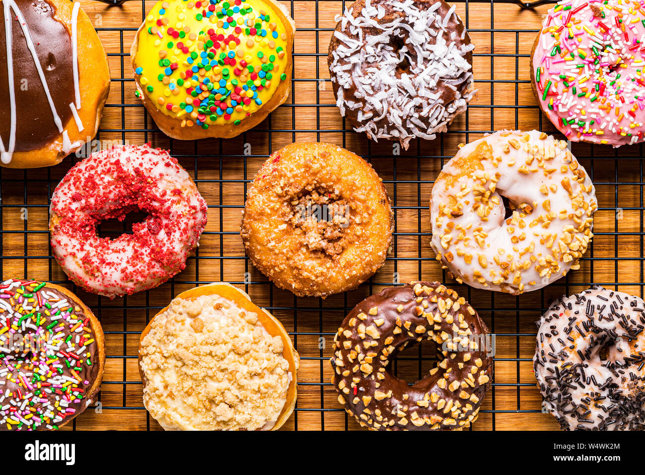 assorted donuts on wire rack on wooden cutting board Stock Photo