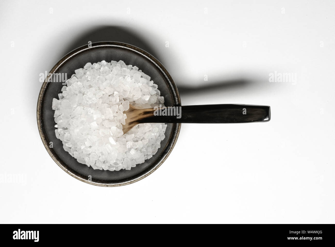 Rock salt in a small black bowl Stock Photo