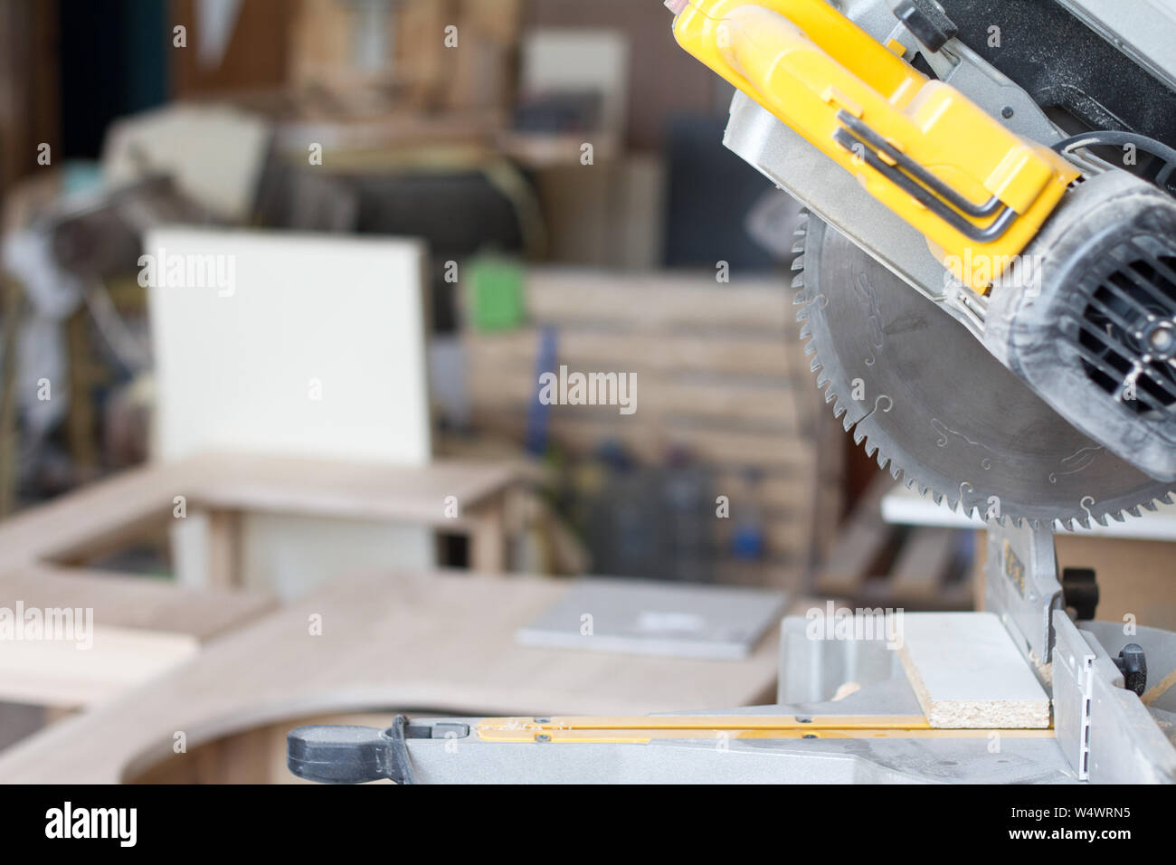Closeup stationary circular saw on a carpentry table on a blurred