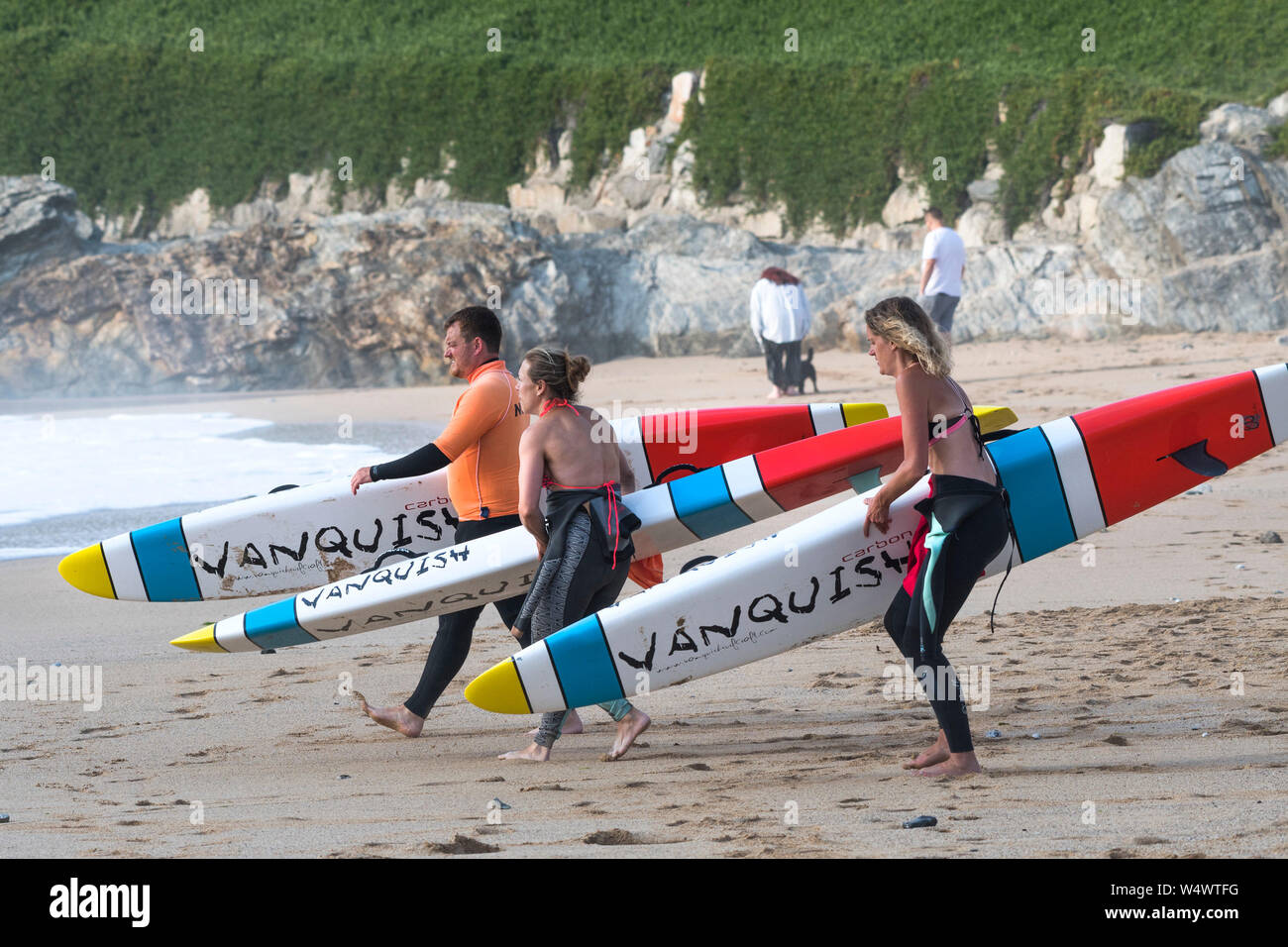 Members of Newquay Surf Life Saving Club carrying Vanquish Life Saving Race Boards starting a training session at Fistral in Newquay in Cornwall. Stock Photo