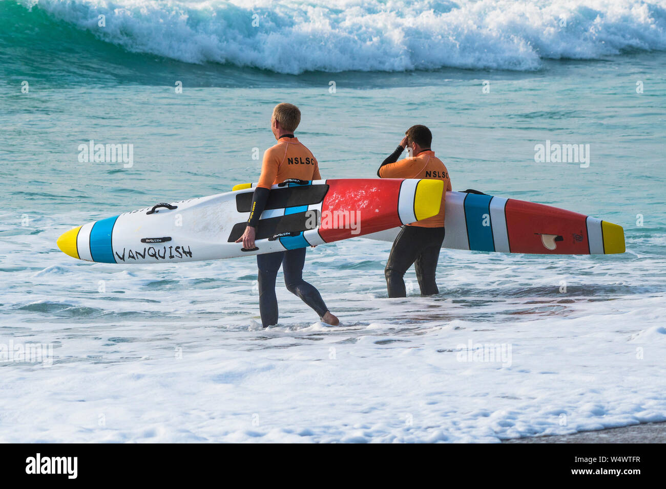 Members of Newquay Surf Life Saving Club carrying Vanquish Life Saving Race Boards starting a training session at Fistral in Newquay in Cornwall. Stock Photo