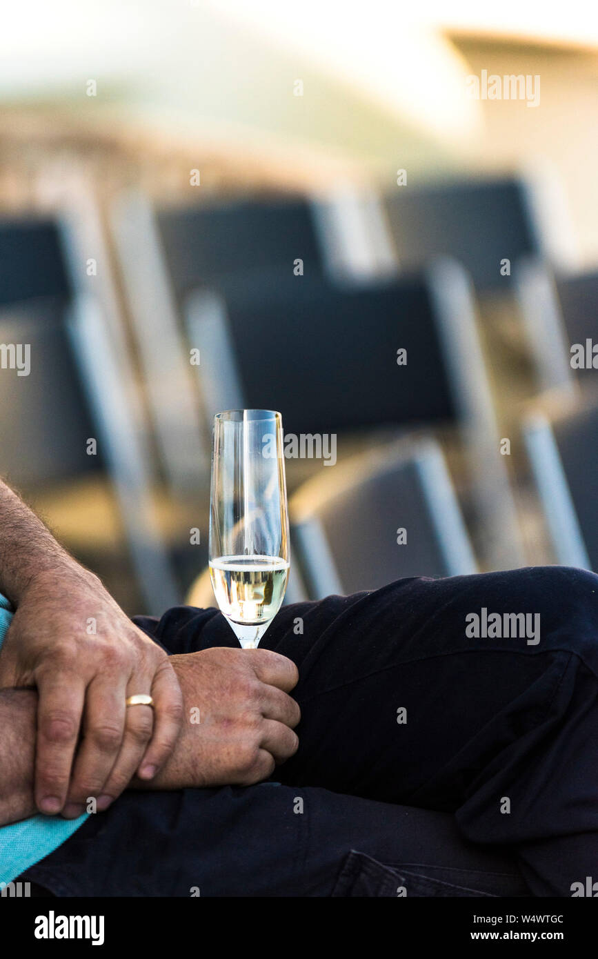 A man relaxing and holding a glass of sparkling wine. Stock Photo