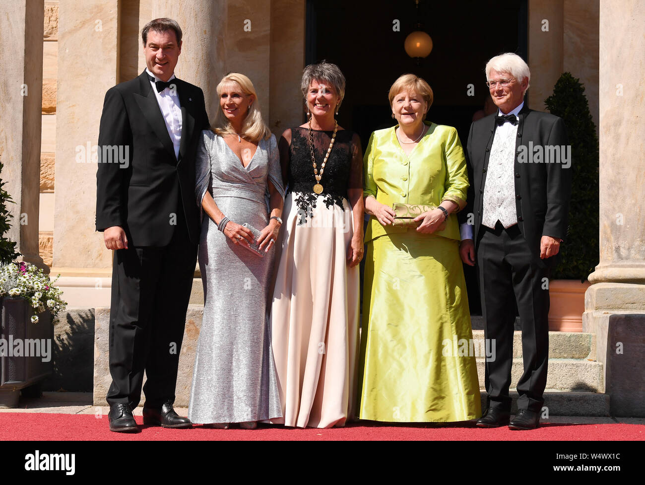Bayreuth, Germany. 25th July, 2019. Federal Chancellor Angela Merkel (CDU, 2nd from right) together with the Bavarian Prime Minister Markus Söder (CSU, l) and his wife Karin Baumüller-Söder (2nd from left) is welcomed by the Mayor of Bayreuth Brigitte Merk-Erbe and her husband Thomas (r) at the beginning of the Bayreuth Festival 2019. The Richard Wagner Festival began in Bayreuth on Thursday. Credit: Tobias Hase/dpa/Alamy Live News Stock Photo