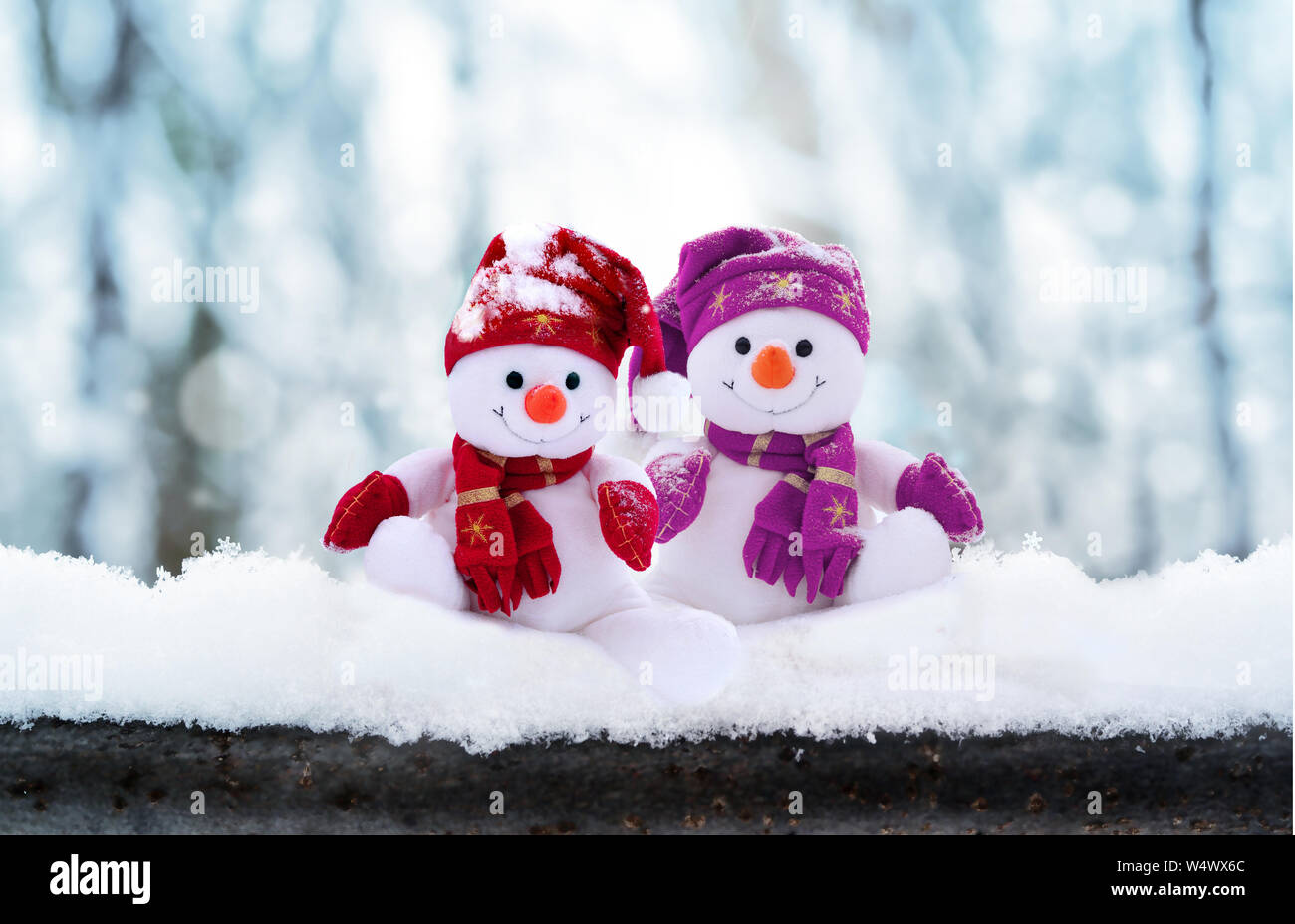Two little snowmen the girl and the boy in caps and scarfs on snow in ...