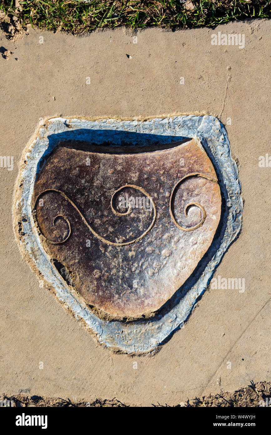 One of the plaques illustrating Iron Age artefacts set into the paving stones of the path up Mam Tor, Peak District, Derbyshire, England, UK Stock Photo