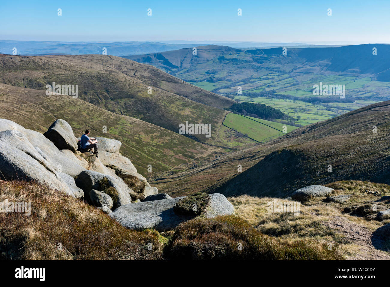 A walker looks down on Edale from the Kinder Scout plateau, Peak District, Derbyshire, England, UK Stock Photo