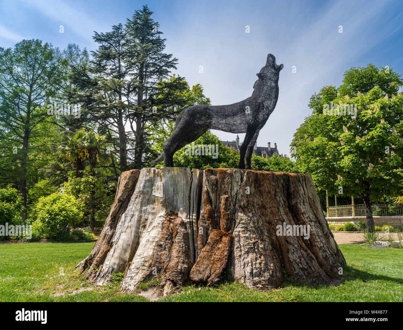 Metal wire sculpture of wolf on tree stump - Loches, France. Stock Photo