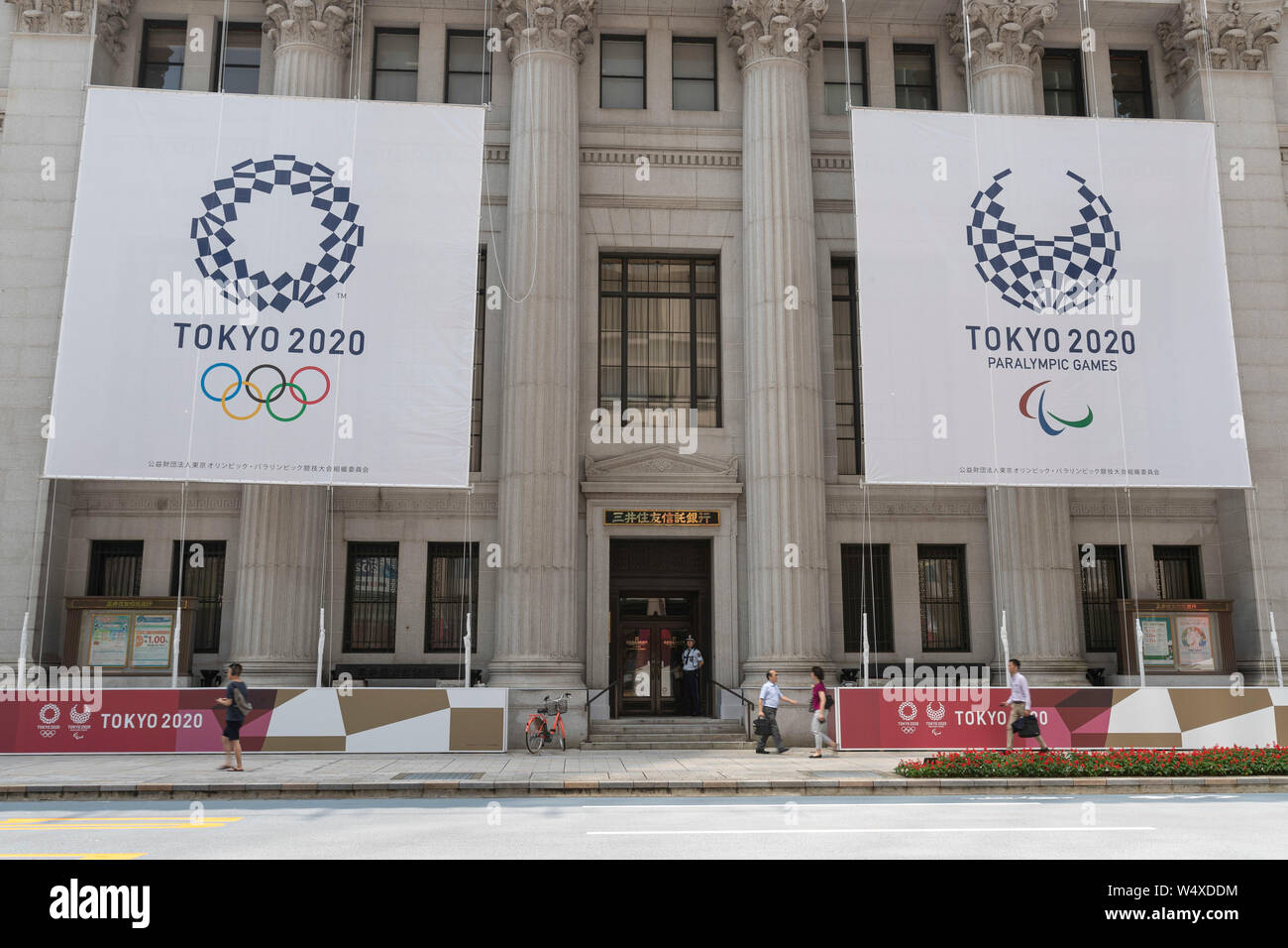 Tokyo, Japan. 25th July, 2019. Huge banners of Tokyo 2020 Olympic Games are on display outside Sumitomo Mitsui Trust Bank to promote the 2020 Tokyo Olympic and Paralympic Games. Tokyo marks one year to go 2020 Olympics decorating with Olympic emblems and photos of Japanese athletes some buildings of Nihonbashi district in Tokyo. The Games are set to open on July 24, 2020. Credit: Rodrigo Reyes Marin/AFLO/Alamy Live News Stock Photo
