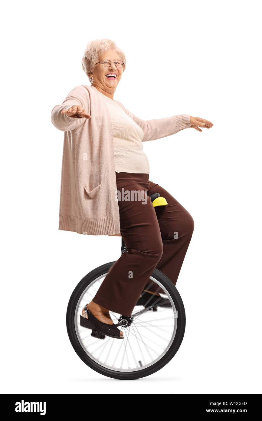 Full length shot of a cheerful senior woman riding a unicycle and ...