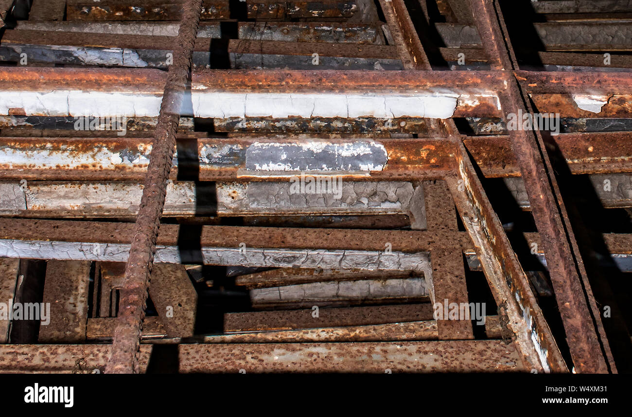 Stack of old rebar and iron with rust and peeling paint inside