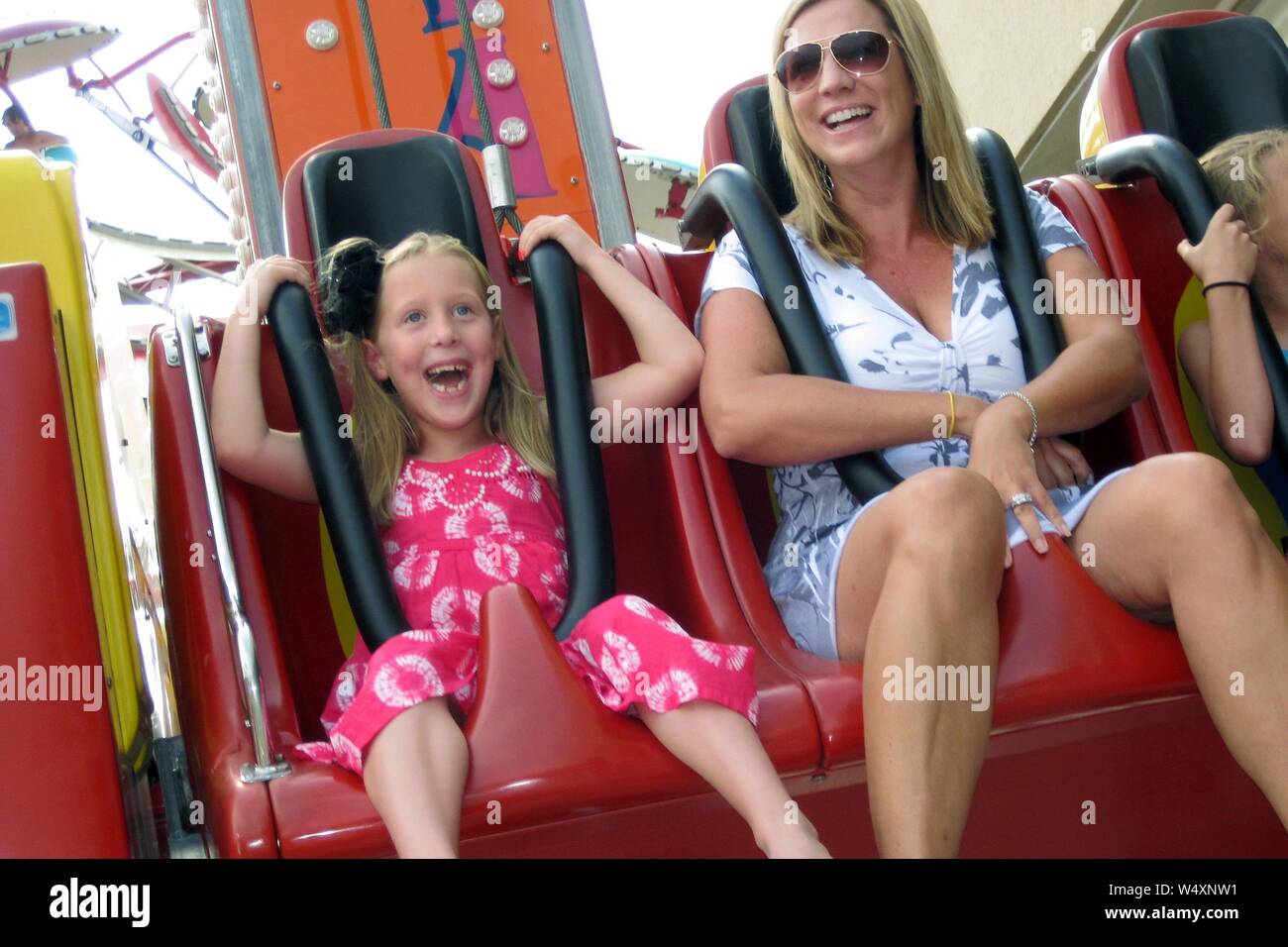 A mother and daughter laugh while on a theme park ride. Stock Photo