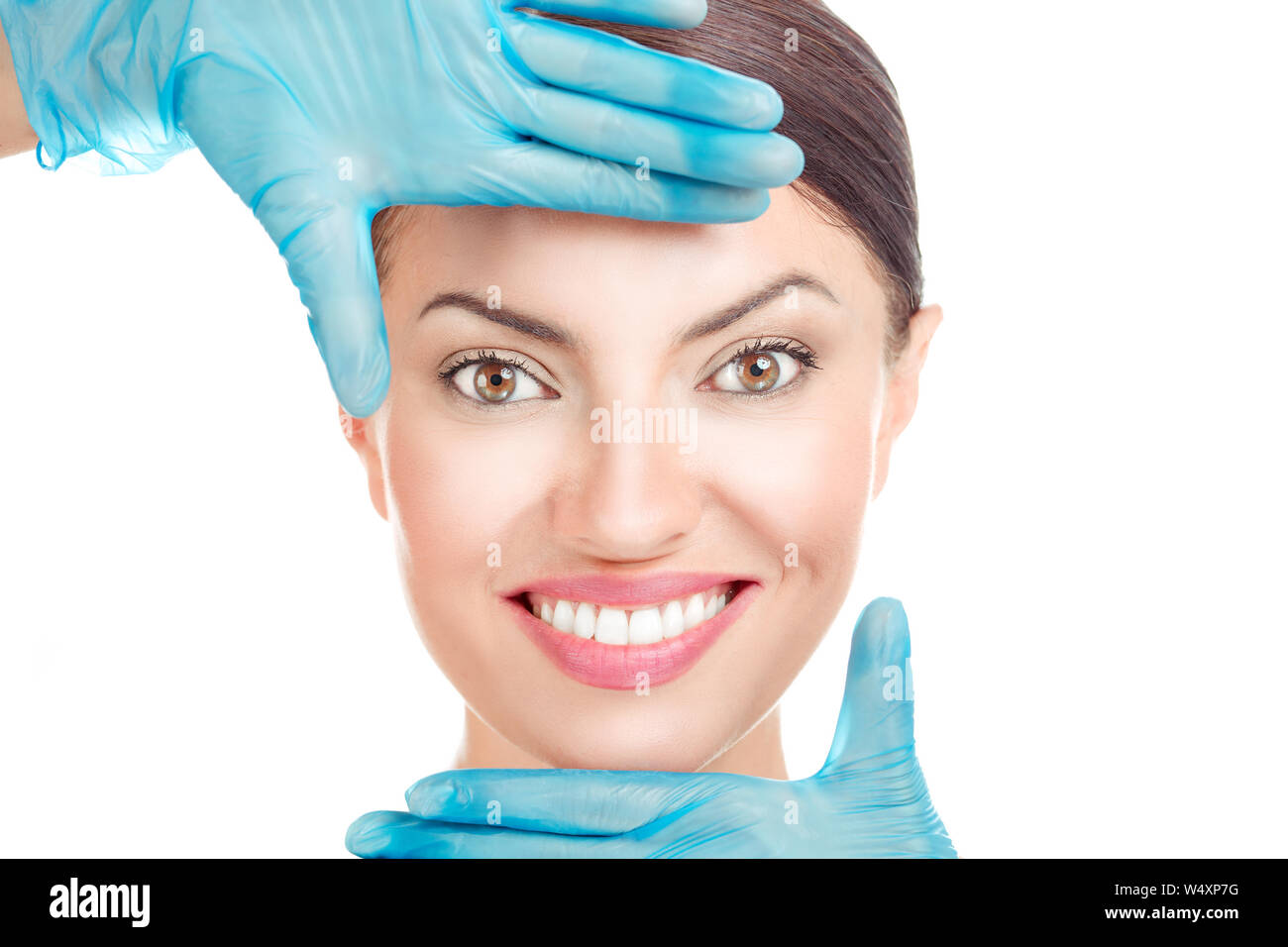 Aesthetic procedure. Doctor hand in gloves shaping a frame around face