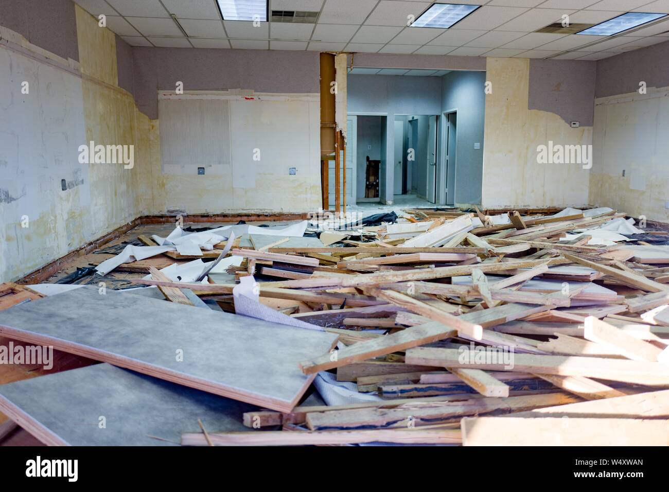 Interior view of closed or out of business retail store whose interior is in the process of being demolished, with debris and wooden boards in a large and disorganized pile, walls stripped of fixtures and paint, in Albany, California, December 18, 2018. () Stock Photo