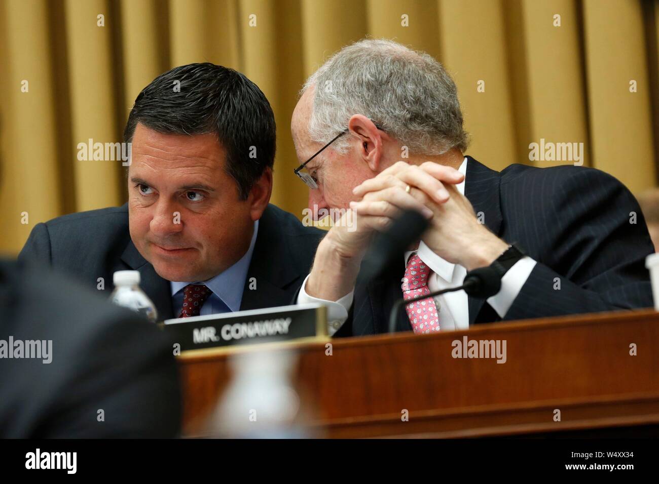 United States Representative Devin Nunes (Republican of California), ranking member, left, and US Representative Michael Conaway (Republican of Texas), right, converse during the questioning of former Trump-Russia special counsel Robert Mueller as he gives testimony before the United States House Permanent Select Committee on Intelligence on the results of his investigation on Capitol Hill in Washington, DC on Wednesday, July 24, 2019.Credit: Stefani Reynolds/CNP (RESTRICTION: NO New York or New Jersey Newspapers or newspapers within a 75 mile radius of New York City) | usage worldwide Stock Photo