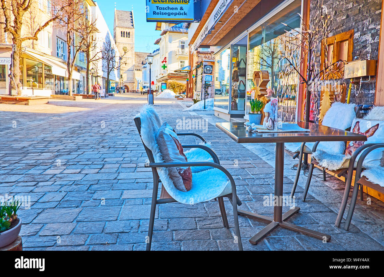 ZELL AM SEE, AUSTRIA - FEBRUARY 28, 2019: Enjoy the open air terrace of cafe in main shopping street of Zell am See resort - Bahnhofstrasse, on Februa Stock Photo