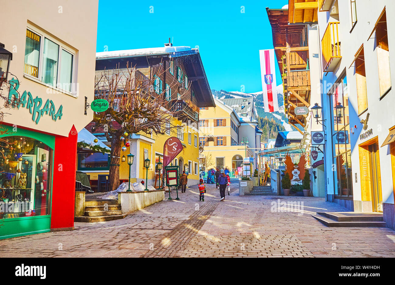 ZELL AM SEE, AUSTRIA - FEBRUARY 28, 2019: The old town street with beautiful townhouses, cozy restaurants, hotels and variety of souvenir and sport st Stock Photo