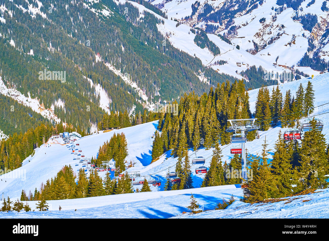 Watch the long route of Kettingbahn chairlift, stretching along the snowy slope of Schmittenhohe mount, Zell am See, Austria Stock Photo