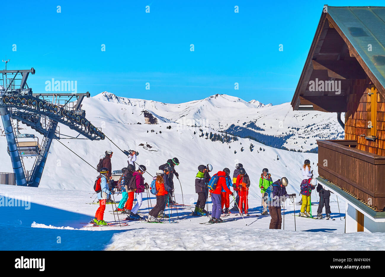 ZELL AM SEE, AUSTRIA - FEBRUARY 28, 2019: The group of young skiers at the start of downhill on top of Schmittenhohe mount, next to the ski lift, on F Stock Photo