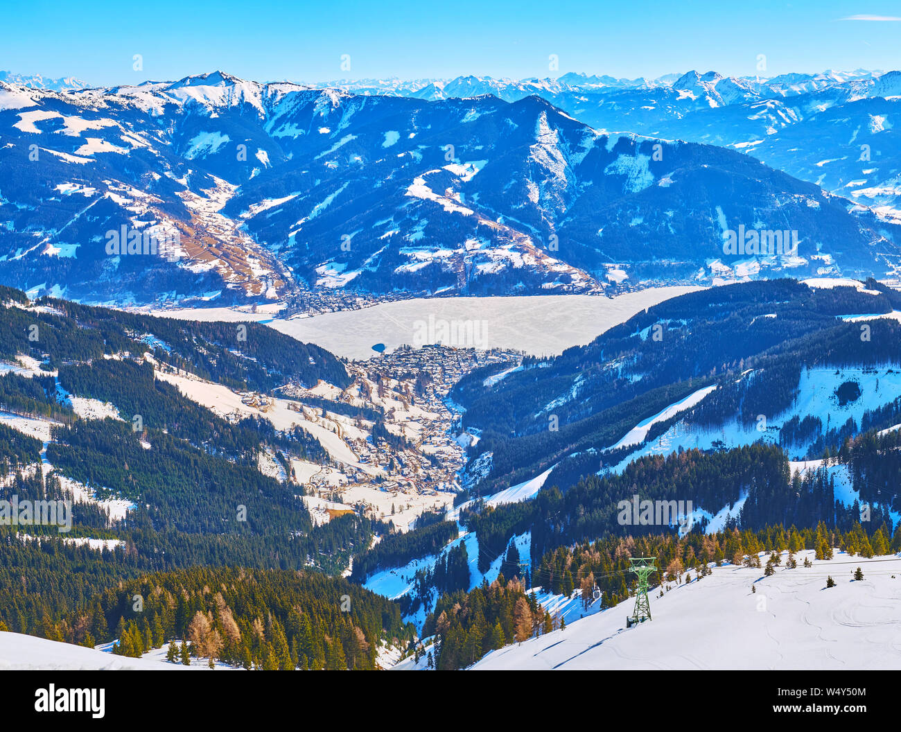 Spectacular view from the peak of Schmitten mount on the snowy Alps of Kaprun and Zell am Zee resorts and the frozen Zeller see (lake), located in hig Stock Photo