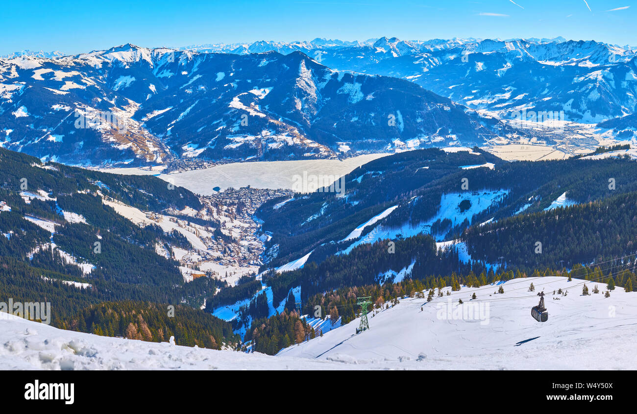Enjoy magnificent Alpine landscape from the top of Schmitten mount with a view on Zell am See resort, frozen Zeller see (lake) and futuristic cabin of Stock Photo