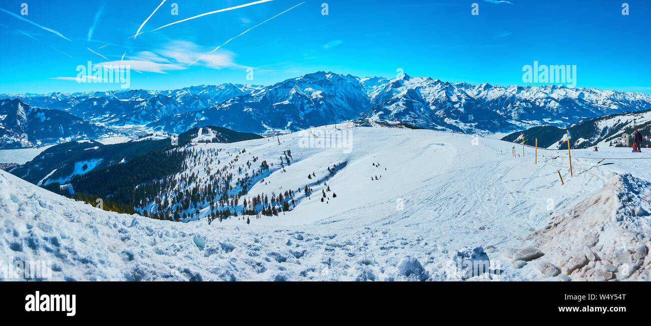 Fine sunny weather on Schmittenhohe mount is perfect chance to observe the winter panorama and enjoy the snowy slopes, sharp Alpine peaks and bright b Stock Photo