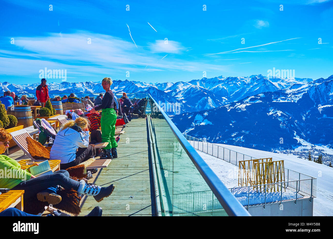 ZELL AM SEE, AUSTRIA - FEBRUARY 28, 2019: Crowded outdoor terrace of lounge Panorama restaurant on top of Schmitten mount with many sportsmen, relaxin Stock Photo