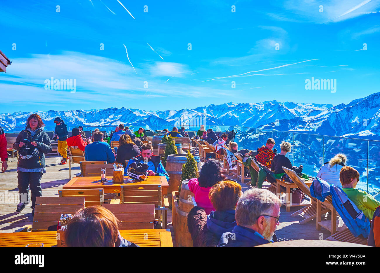 ZELL AM SEE, AUSTRIA - FEBRUARY 28, 2019: The skiers and other sportsmen enjoy the sunny open air lounge restaurant on top of Schmitten mount, on Febr Stock Photo